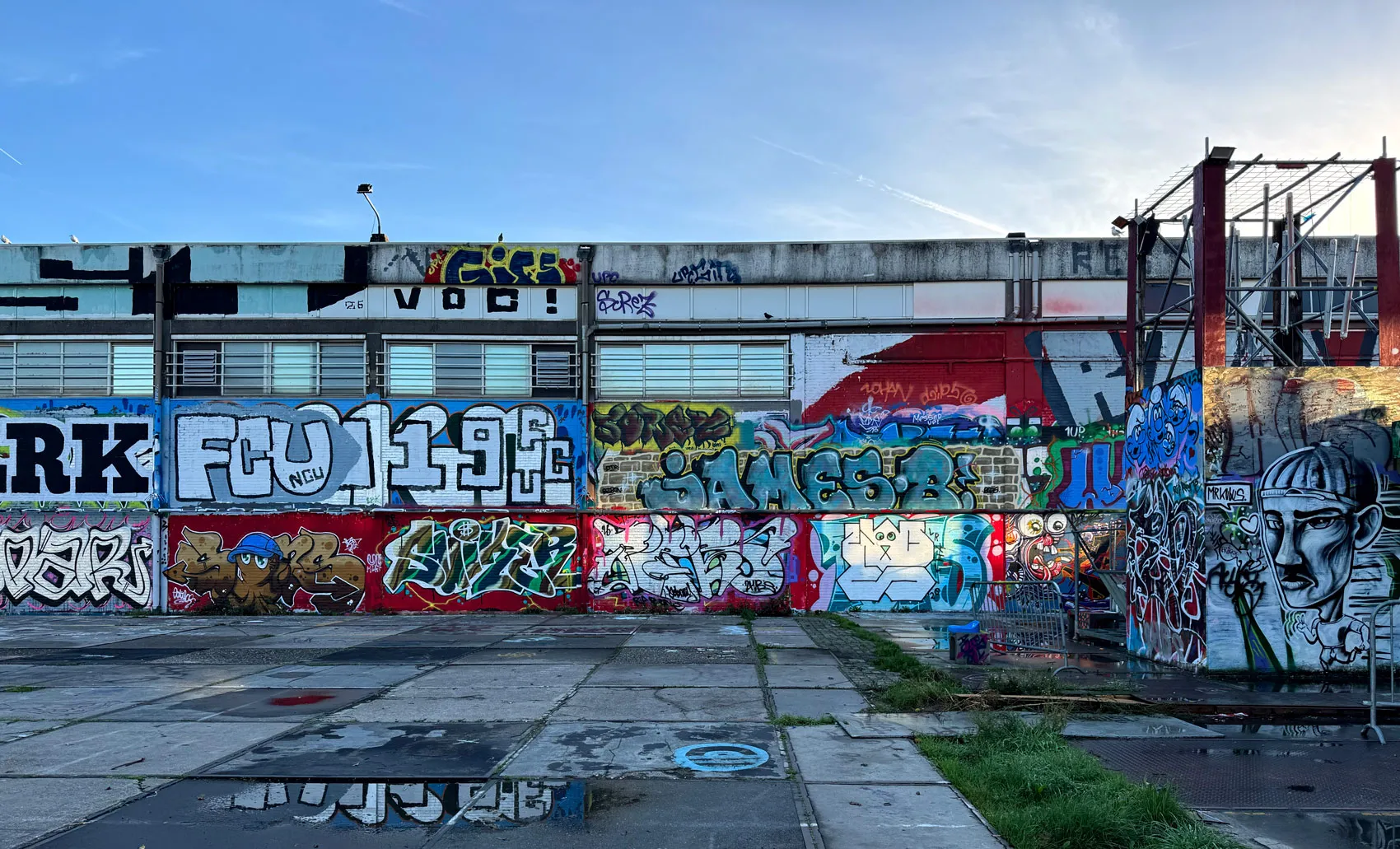 loods vol graffiti onder een blauwe lucht